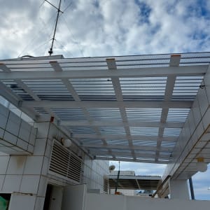 גג מתכת עם רשת מעל מבנה לבן