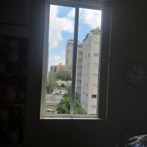 חלון אלומיניום עם נוף עירוני ברקע