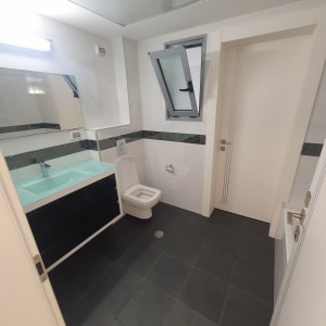 חדר אמבטיה עם כיור, אסלה וחלון פתוח