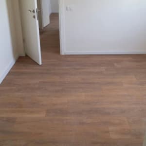 רצפת פרקט עץ בחדר ריק עם דלת פתוחה