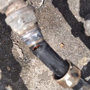 צינור מתכת עם מפתח צינורות אדום על הקרקע