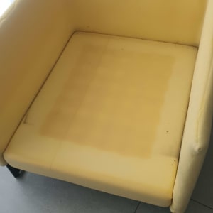 כרית ישיבה צהובה עם סימני שחיקה