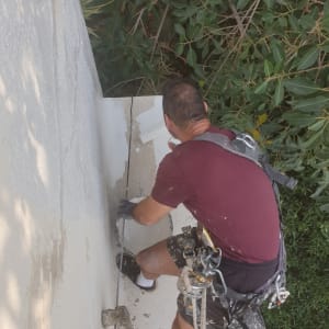 אדם מורח חומר איטום על קיר חיצוני