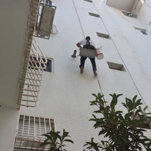 אדם תלוי על חבל עם דלי ליד צינור