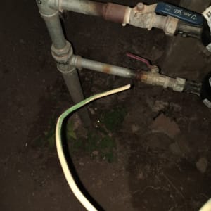 צינורות מתכת וברזים עם חוט חשמל חשוף