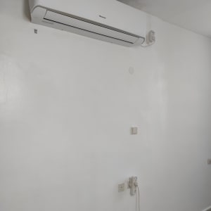 מזגן מותקן על קיר לבן עם שקע חשמל