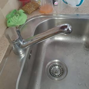 ברז נירוסטה בכיור מטבח עם מים זורמים