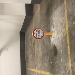 שלט עצור על עמוד צהוב בחניון תת קרקעי