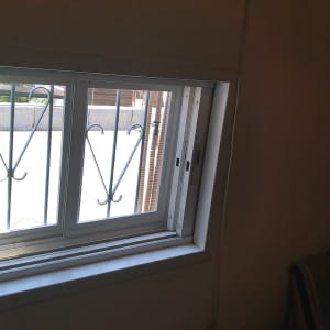 חלון אלומיניום עם מסגרת לבנה וסורגים