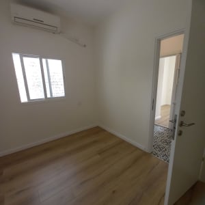 רצפת פרקט עץ בהירה בחדר ריק עם דלת פתוחה