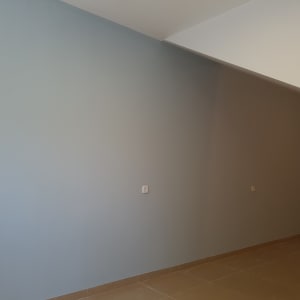 קיר צבוע בגוון כחול בהיר עם שקע חשמל