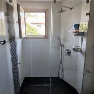 מקלחת עם ראש גשם, מדף עם מוצרי רחצה