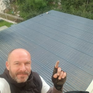 גג מתכת גלי עם ברגים, אדם מצביע עליו