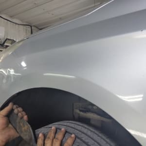 ידיים מתקנות פגוש רכב עם כלי עבודה