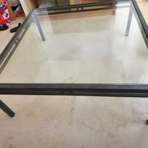 שולחן זכוכית עם מסגרת מתכת על רצפה בהירה