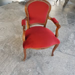 כיסא עץ מרופד בבד אדום עם מסמרים דקורטיביים