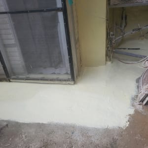 איטום רצפה עם חומר לבן ליד קיר וחלון