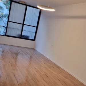 חדר עם רצפת עץ חדשה ותאורה מודרנית