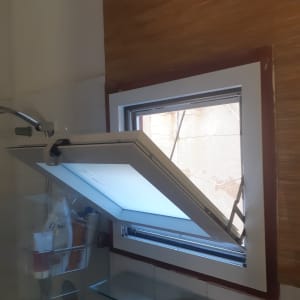 חלון אלומיניום פתוח עם מסגרת לבנה