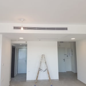 פתחי מיזוג אוויר בתקרה עם סולם בחדר