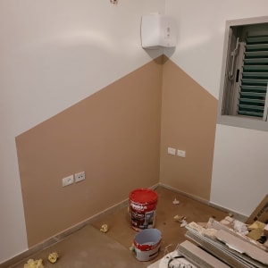 פחיות צבע על הרצפה בחדר צבוע חלקית