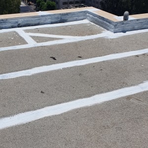 קווים לבנים של חומר איטום על גג בטון