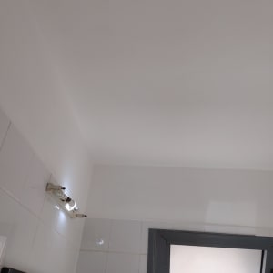 קיר צבוע בלבן עם תאורה עליונה