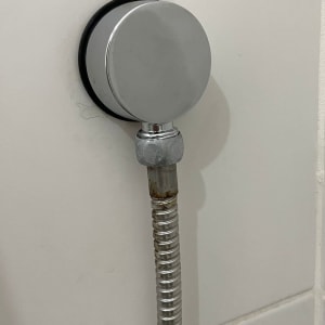 צינור מתכת מחובר לקיר עם חיבור עגול