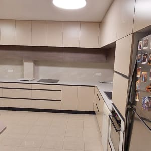 מטבח מודרני עם ארונות בהירים ומקרר עם מגנטים