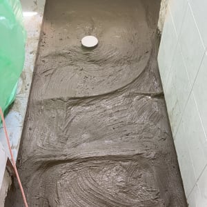 רצפת בטון טרי עם פתח ניקוז בשיפוץ חדר אמבטיה