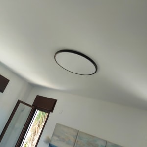 תאורה עגולה בתקרה וסולם עץ בחדר