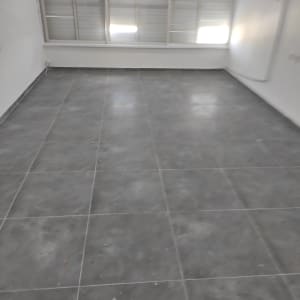 רצפה אפורה עם לכלוך קל, חלון גדול ברקע