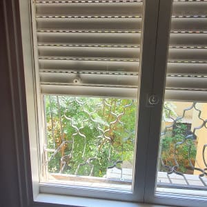 חלון זכוכית עם תריסים פתוחים חלקית