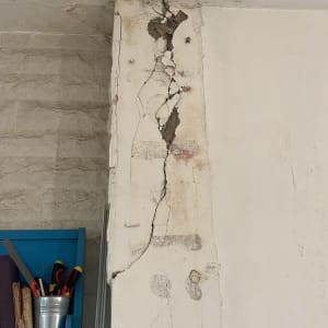 סדק עמוק ונזק לטיח ולצבע בקיר ותקרה בדירה