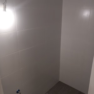 קיר אריחים לבנים עם חיבורים לצנרת