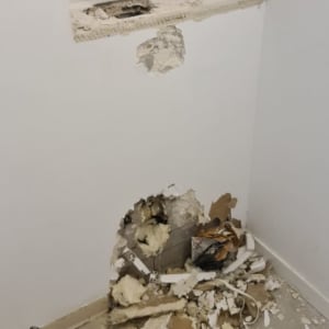 קיר עם חור ושברי טיח על הרצפה