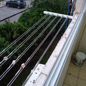 חבלי כביסה מותקנים על מתקן חיצוני במרפסת