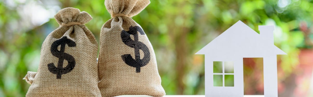 אילוסטרציה לריבית פריים במשכנתא - שקי כסף ודגם של בית על מאזניים