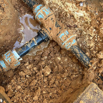 צינור מים שבור באדמה עם נזילה