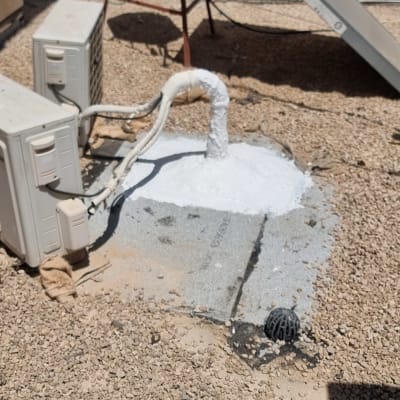 צינור אטום בחומר לבן על גג עם חצץ