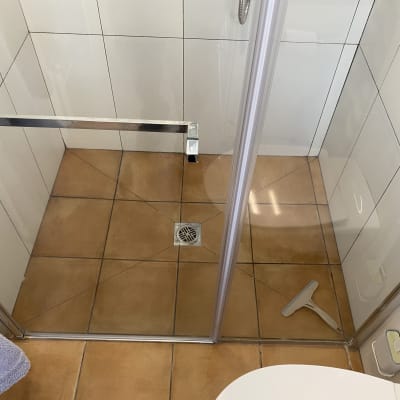 מקלחון עם רצפת אריחים ומגב לניקוי