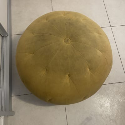 שרפרף עגול צהוב עם כתמים על הרצפה