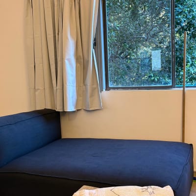 ספה כחולה ליד חלון עם וילון לבן