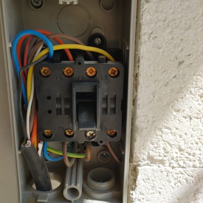 חוטי חשמל צבעוניים בתוך תיבת חיבורים