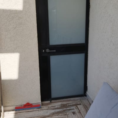 דלת עם ידית מתכת על רקע קיר לבן