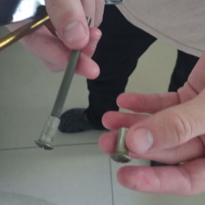 ידיים מחזיקות ברגים וכלי עבודה