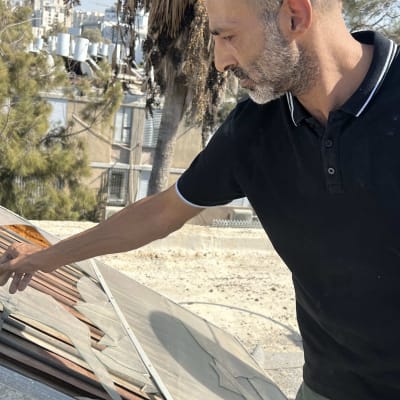 אדם בודק צינורות על גג