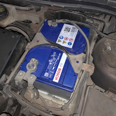 מצבר רכב כחול עם כבלים מחוברים