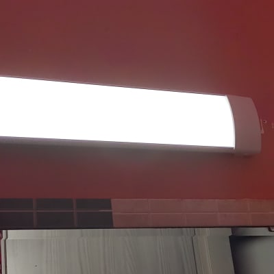 מנורת קיר מוארת על קיר אדום