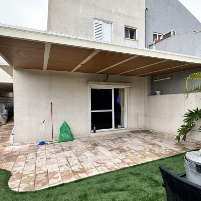 פרגולה מאלומיניום עם גג עץ בחצר בית